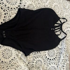 Body suit with an open and strapped back style and criss crossed chest slit